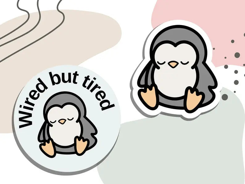 "Wired but tired" sleepy penguin stickers shown digitally, designed by NeurodiverseTea