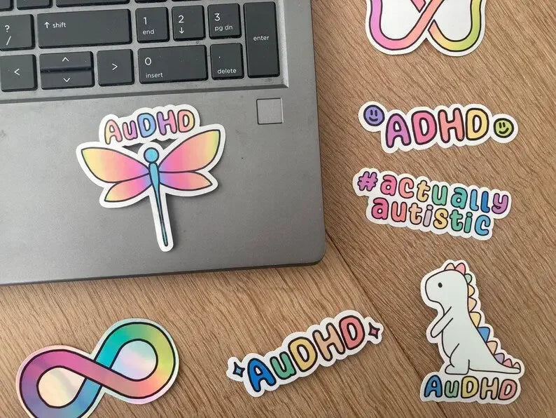 The handmade AuDHD symbol sticker shown as laptop sticker, made by NeurodiverseTea