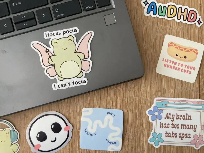Relatable ADHD frog sticker shown as laptop sticker, handmade by NeurodiverseTea