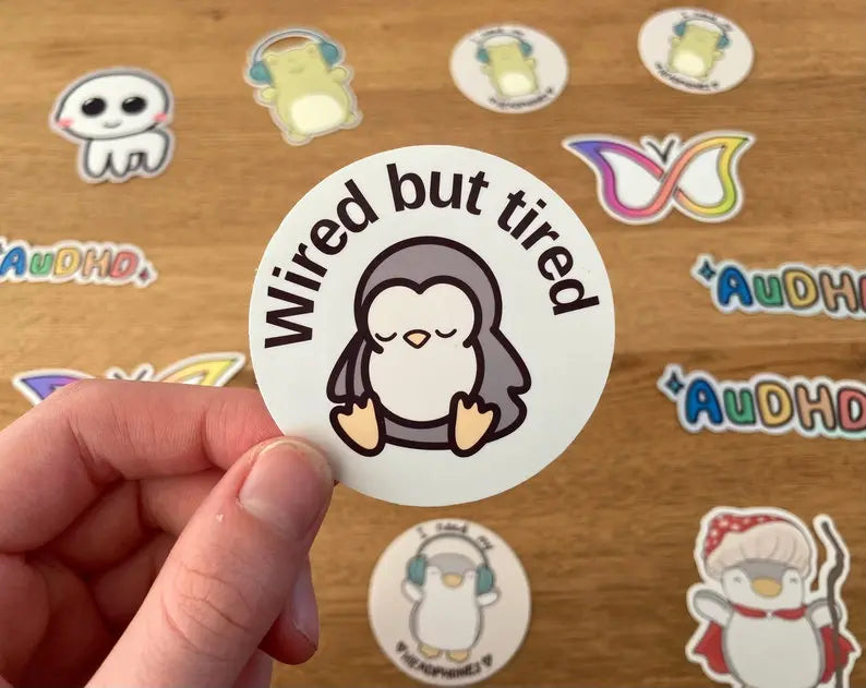 "Wired but tired" sleepy penguin stickers with text, handmade by neurodiveristy themed small business:  Neurodiversetea